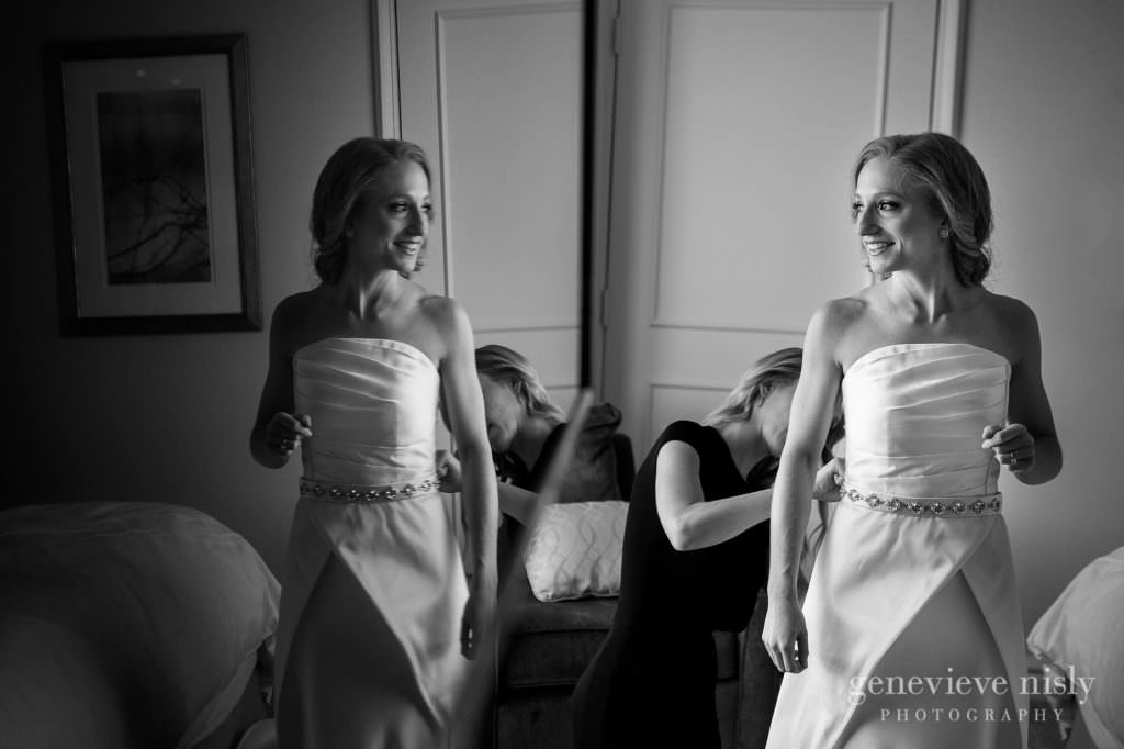 Bride getting into her wedding dress on her wedding day.