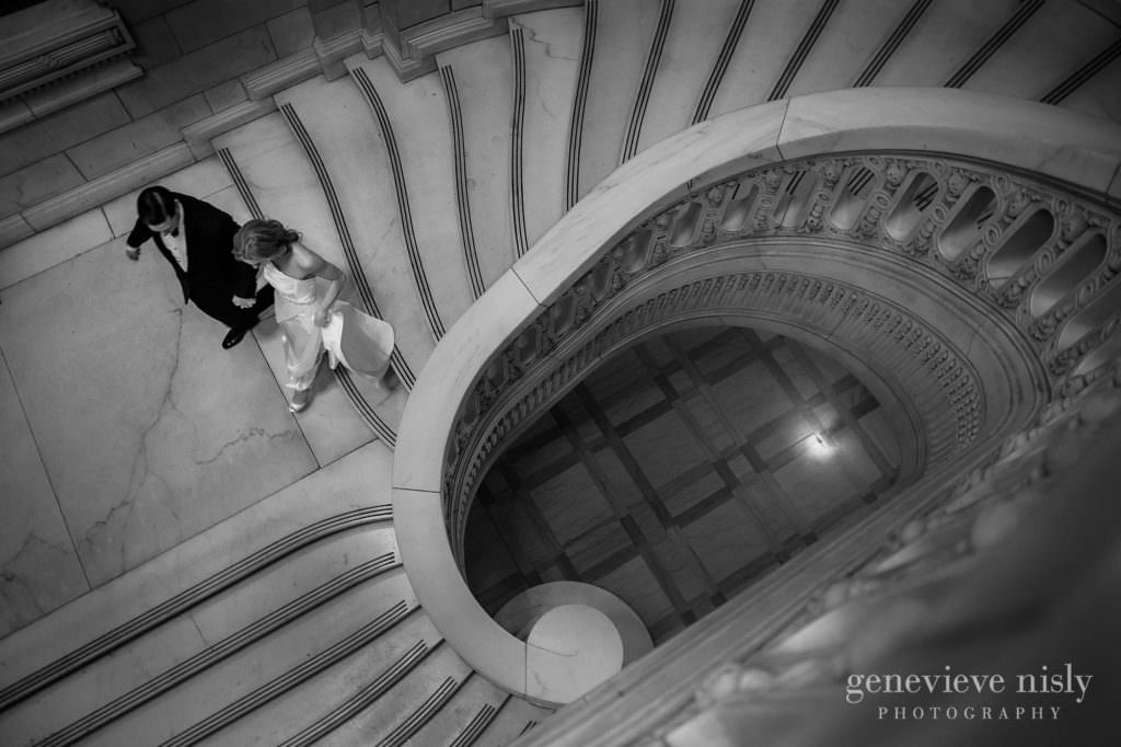 Bride and groom walk down grand staircase at the old courthouse.
