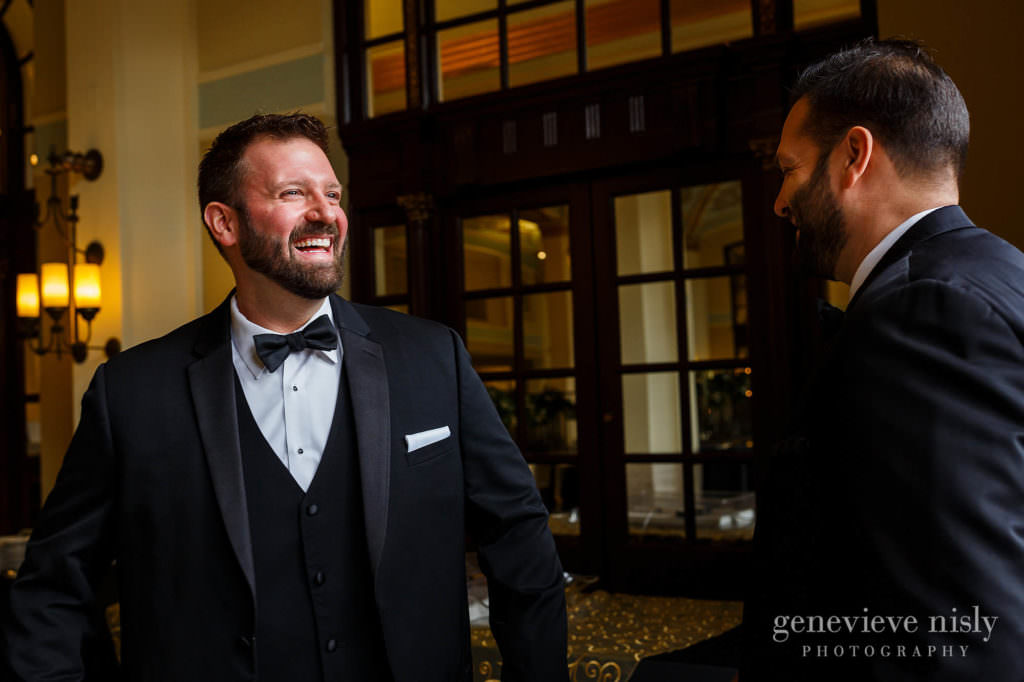 Groom smiles at his groomsman at the Onesto Lofts.
