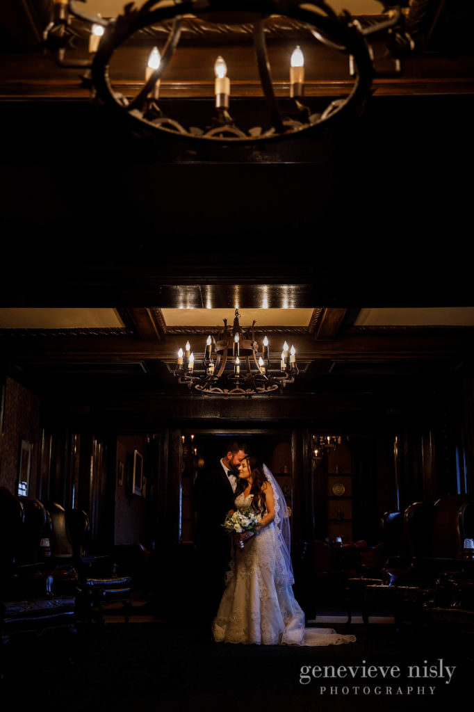 Bride and groom under the chandeliers at the Canton Club.