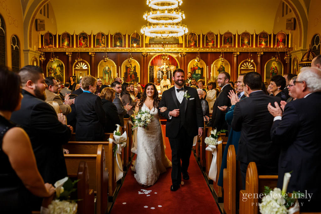 Bride and groom walk back down the aisle at the end of the wedding ceremony at St. Haralambos Church.