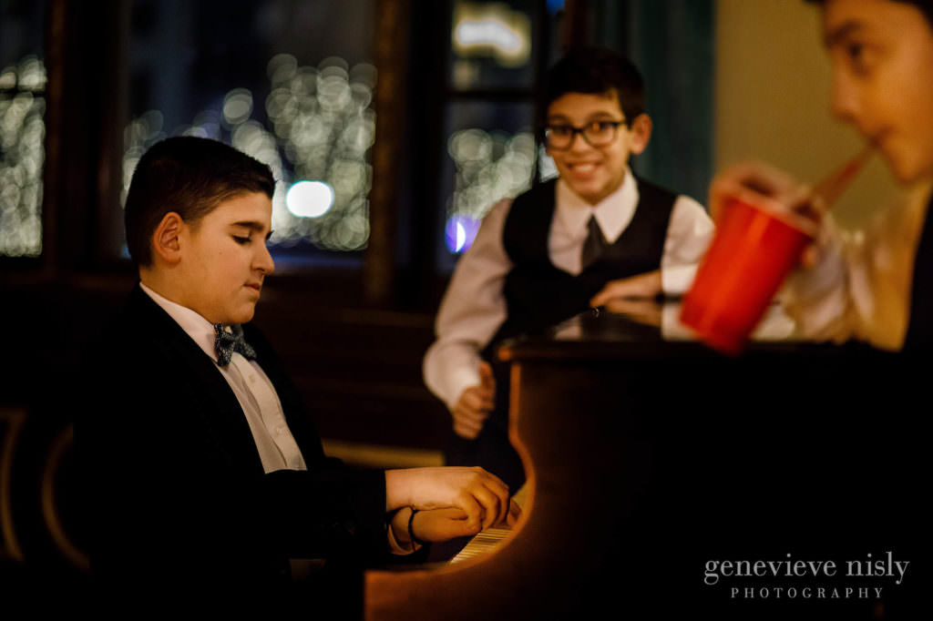 Wedding guests play the piano in the lobby of Onesto Lofts.