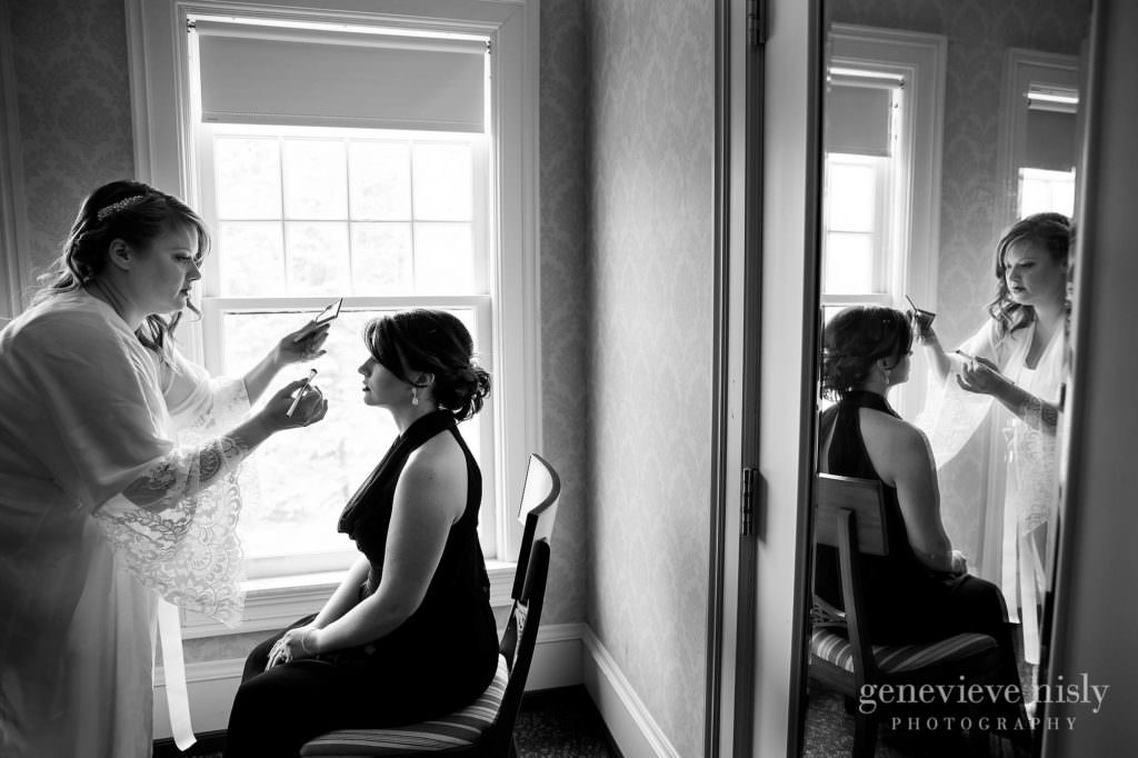 The bride applies makeup to her bridesmaid on her wedding day at Mooreland Mansion.