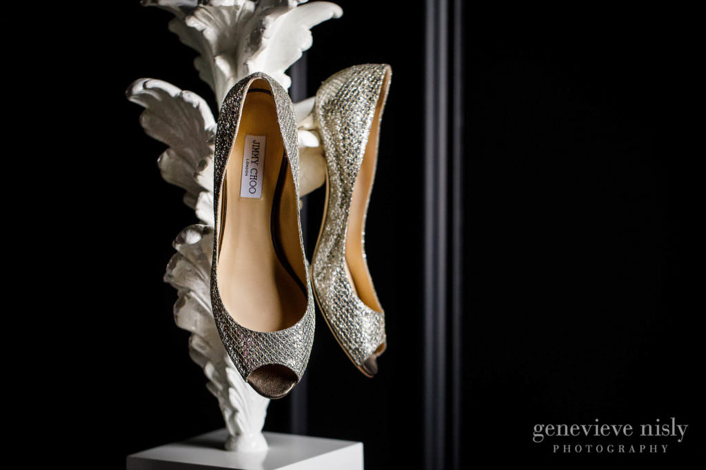 A Bride's sequined wedding shoes hanging on a lamp.