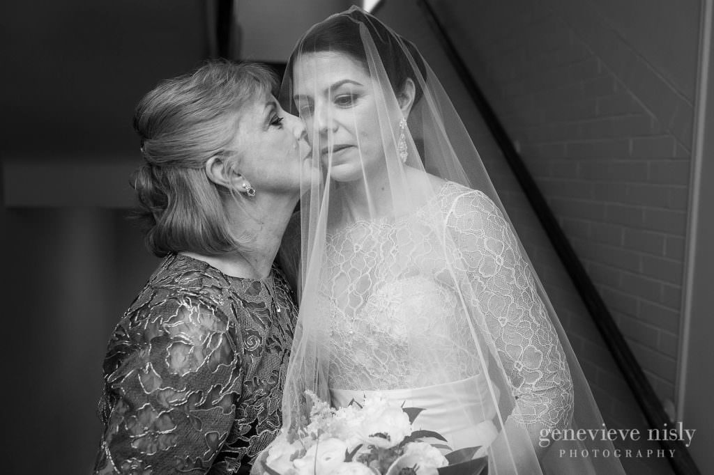 The mother of the bride kisses the bride on the cheek moments before walking down the aisle.