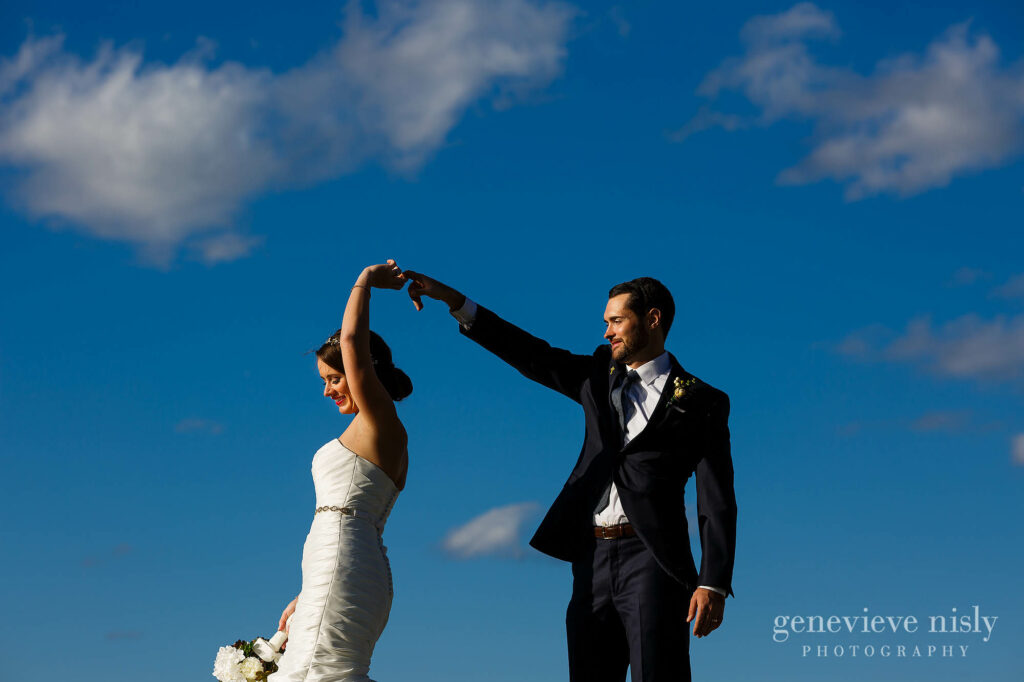 Bride and groom dance in front of a blue sky during their wedding at City Hall Rotunda in Cleveland, Ohio.