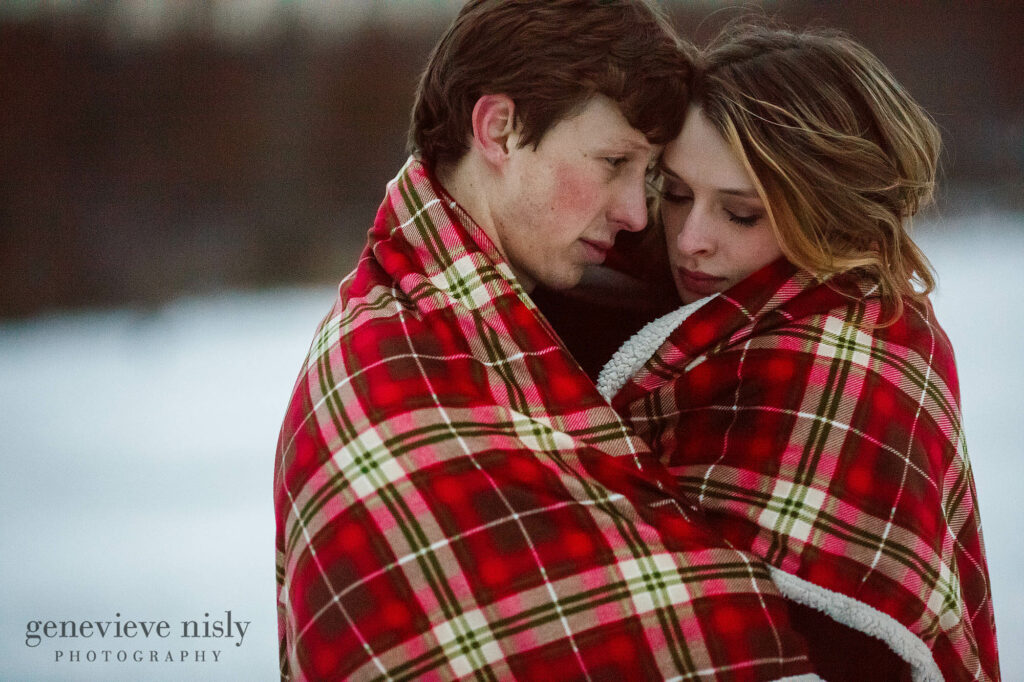Michael and Jacee snuggle under a blanket during their winter engagement session.