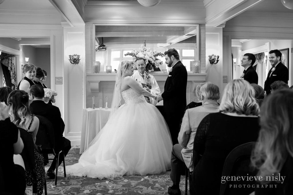 The bride and groom hold hands during their ceremony at Mooreland Mansion in Kirkland.