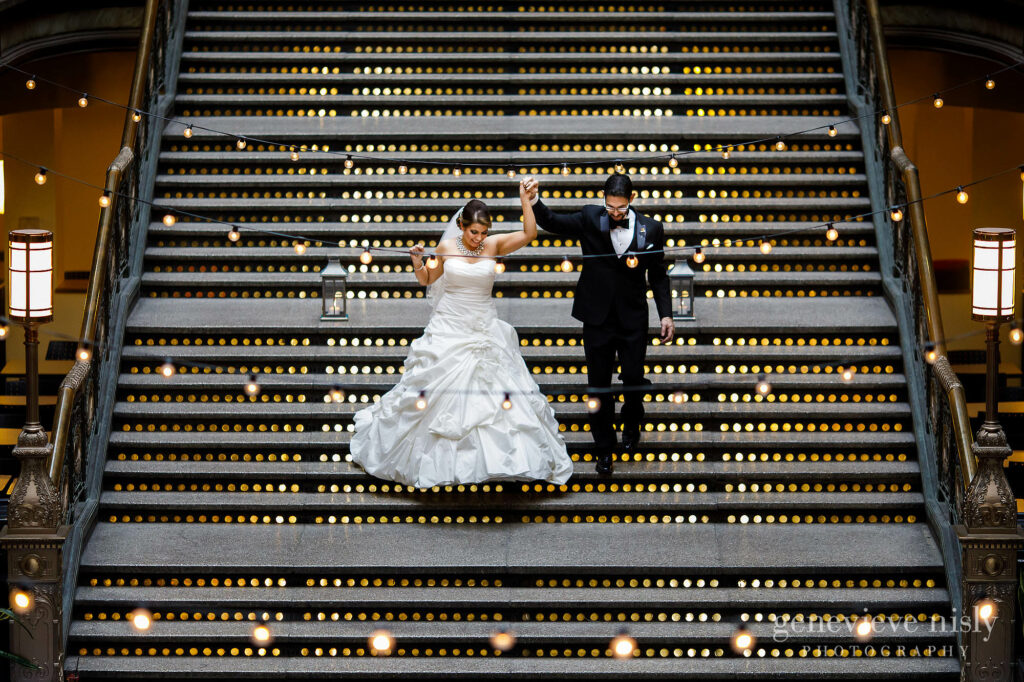 Cameron and Daniel walk down the grand staircase as they are introduced into the reception during Hyatt Arcade wedding in Cleveland, Ohio.