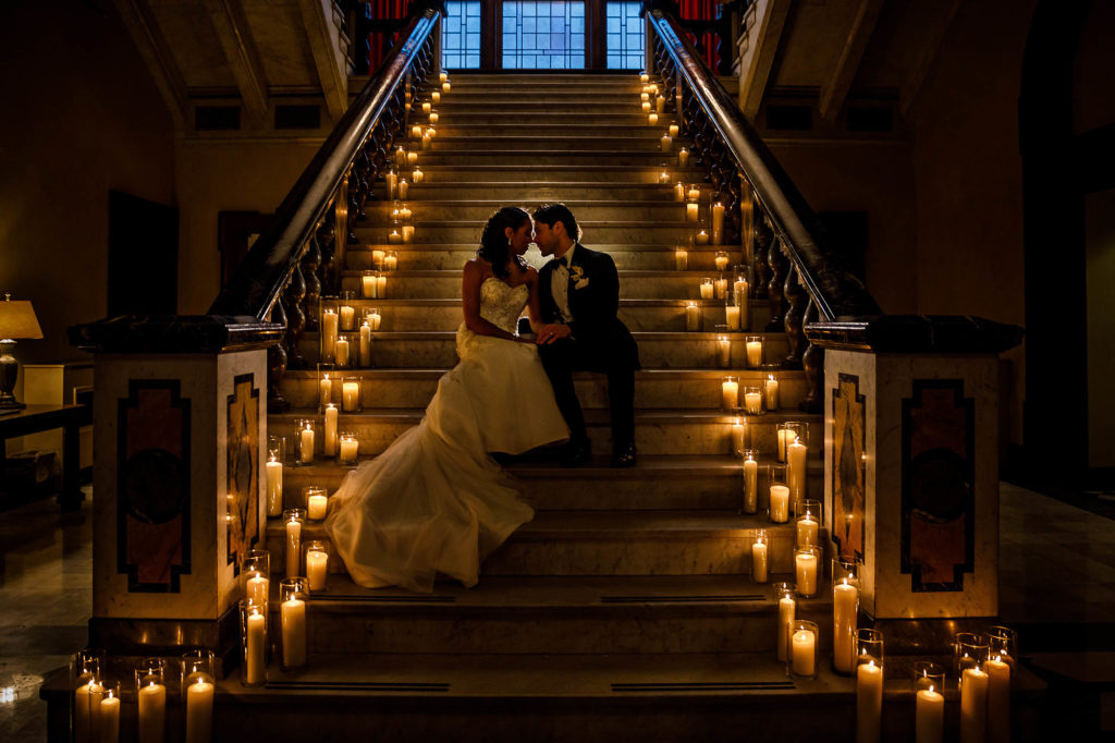 Bride and groom take a moment on candle lit steps of The Union Club in Cleveland during their wedding.