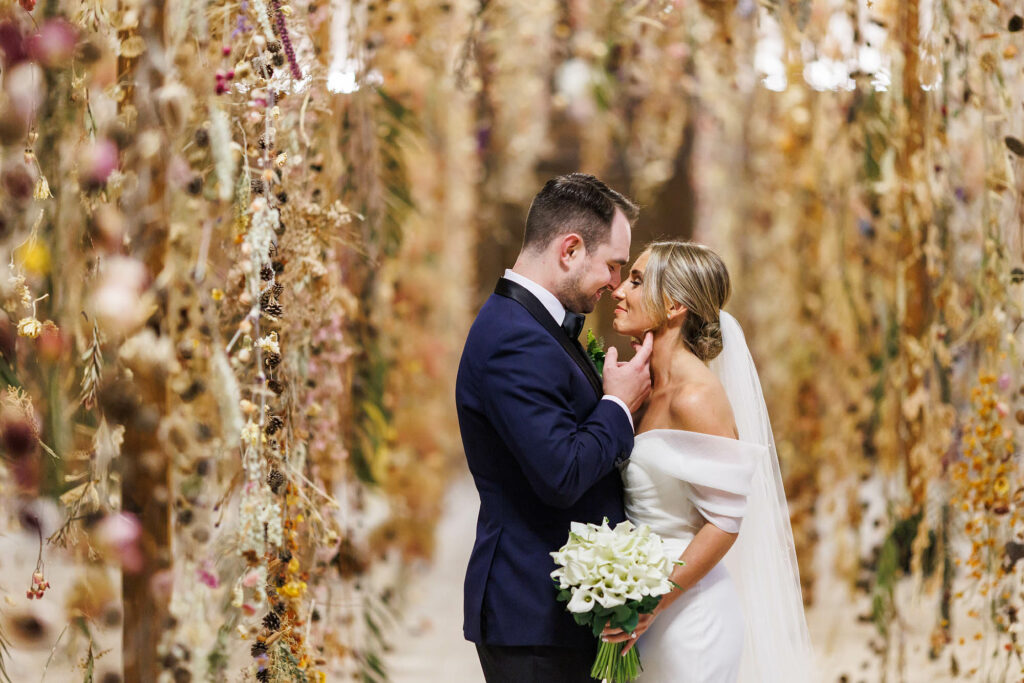 Bride and Groom embrace surrounded by thousands of dried flowers at the Cleveland Public Library.